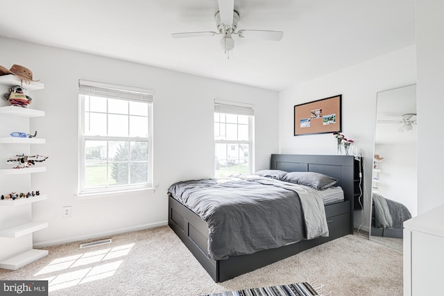 carpeted bedroom featuring baseboards, a ceiling fan, and visible vents