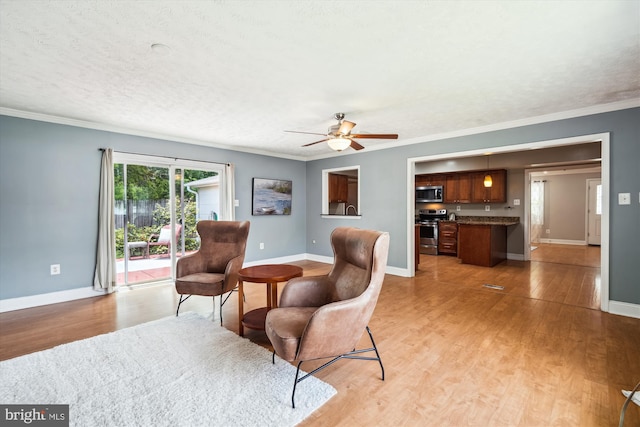 13446 Overbrook Ln, Bowie, MD 20715 - living area featuring light wood-style flooring, a ceiling fan, crown molding, baseboards, and a textured ceiling