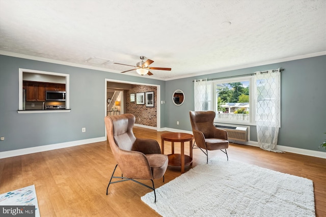 13446 Overbrook Ln, Bowie, MD 20715 - living area featuring baseboards, a wall mounted AC, wood finished floors, ornamental molding, and a ceiling fan