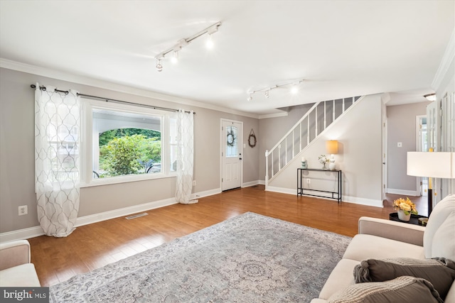 13446 Overbrook Ln, Bowie, MD 20715 - living area with rail lighting, ornamental molding, stairway, wood finished floors, and baseboards