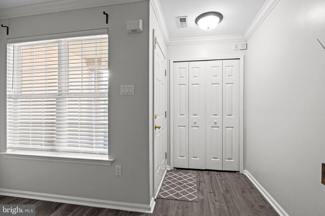 foyer with baseboards, ornamental molding, dark wood-style flooring, and visible vents