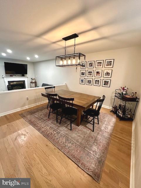 dining room featuring recessed lighting, baseboards, wood finished floors, and a fireplace