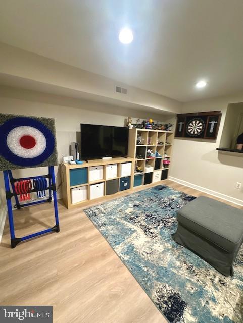 living room featuring recessed lighting, baseboards, visible vents, and wood finished floors