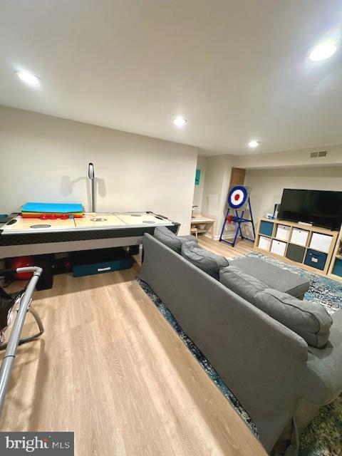 living area with visible vents, recessed lighting, and wood finished floors