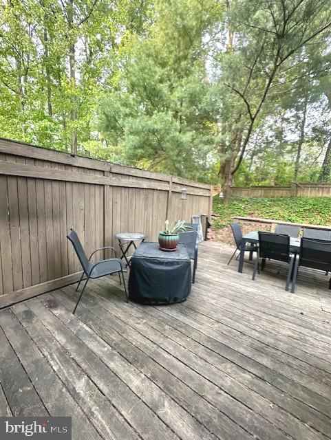 wooden terrace featuring fence and outdoor dining space