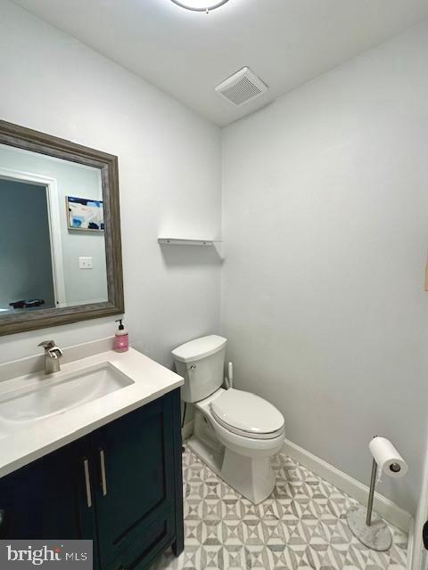 bathroom with visible vents, tile patterned floors, toilet, and vanity