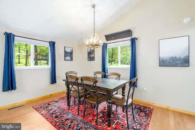 dining space featuring an inviting chandelier, lofted ceiling, a wealth of natural light, and visible vents