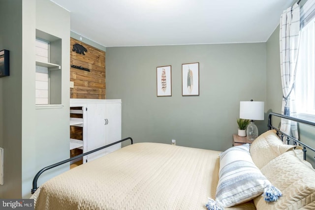 bedroom featuring wood walls