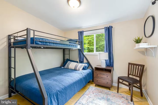 bedroom featuring baseboards and lofted ceiling