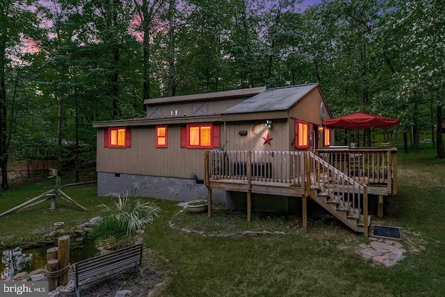 rear view of property with a lawn, stairway, a deck, and crawl space