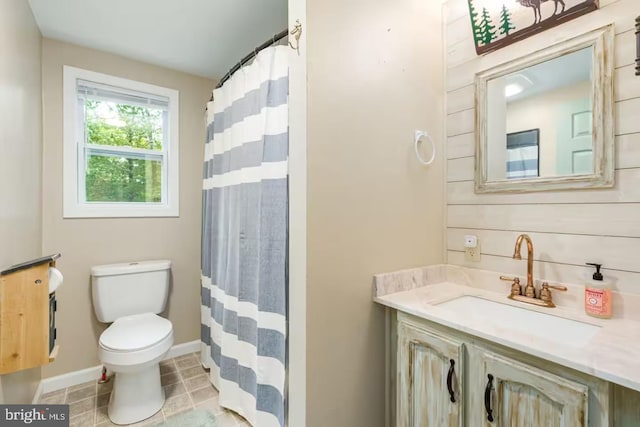 full bath featuring toilet, baseboards, curtained shower, and vanity