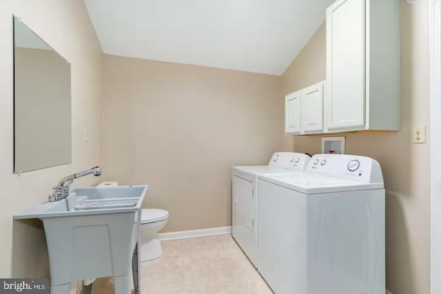 laundry room featuring laundry area, a sink, baseboards, light tile patterned floors, and washer and clothes dryer