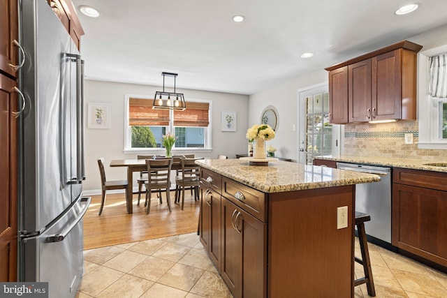 kitchen with decorative backsplash, a kitchen island, appliances with stainless steel finishes, light tile patterned floors, and recessed lighting