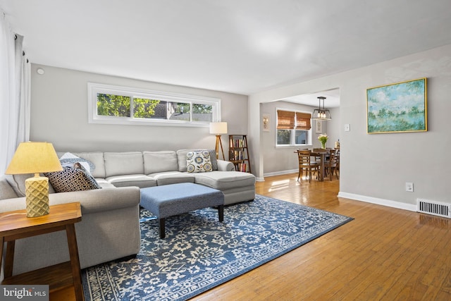 living area featuring baseboards, hardwood / wood-style floors, and visible vents