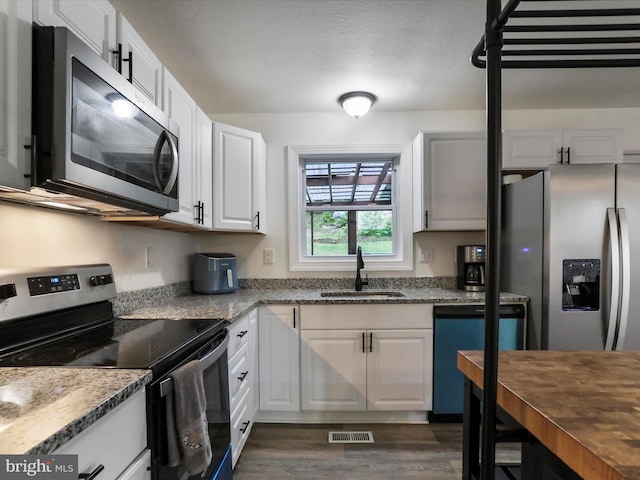 74 Red Maple Ln, Harpers Ferry, WV 25425 - kitchen with a sink, stainless steel appliances, visible vents, dark wood finished floors, and white cabinets