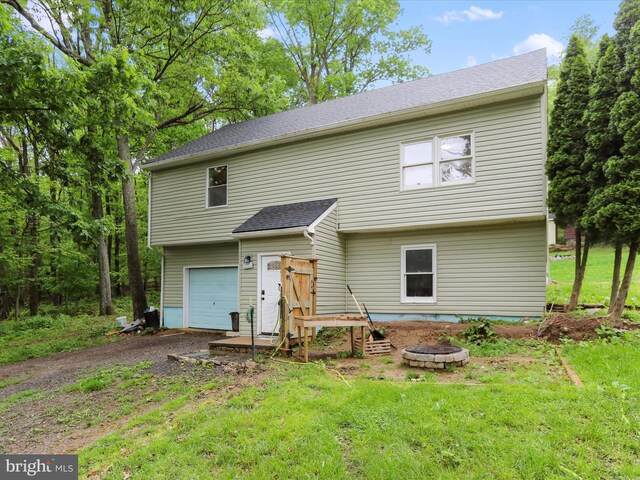 74 Red Maple Ln, Harpers Ferry, WV 25425 - rear view of house featuring a garage, a fire pit, roof with shingles, a yard, and driveway