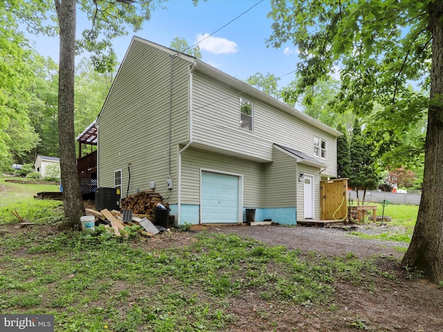 74 Red Maple Ln, Harpers Ferry, WV 25425 - back of property featuring central air condition unit, driveway, fence, and a garage