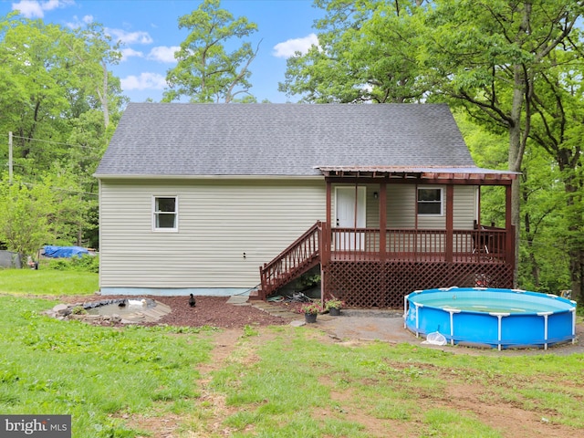 74 Red Maple Ln, Harpers Ferry, WV 25425 - rear view of house featuring a shingled roof, a yard, stairway, and an outdoor pool