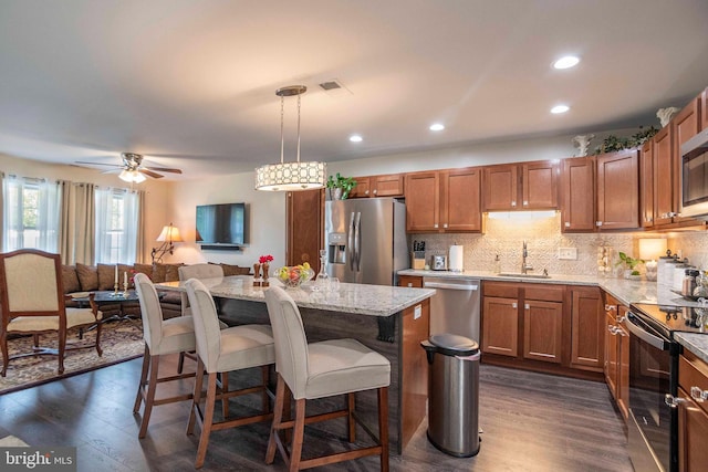 252 Parkside Ct, Woodstock, VA 22664 - kitchen with appliances with stainless steel finishes, a sink, a breakfast bar area, a center island, and dark wood-type flooring