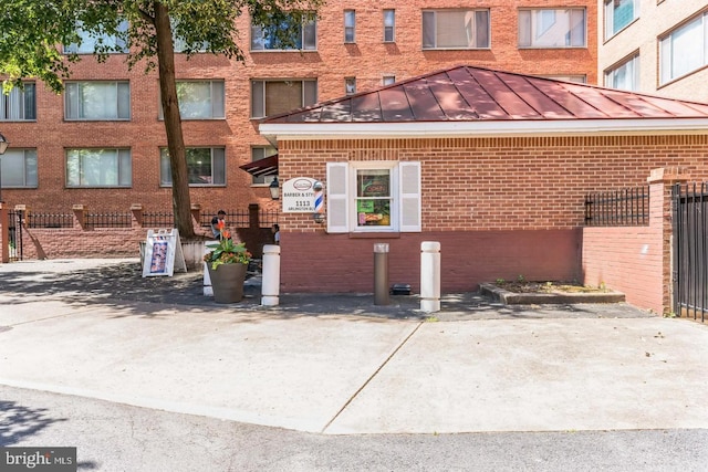 1021 Arlington Blvd Unit 237, Arlington, VA 22209 - view of side of property with a standing seam roof, fence, and brick siding
