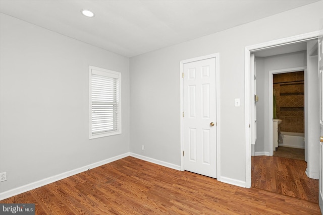 unfurnished bedroom with recessed lighting, baseboards, and wood finished floors