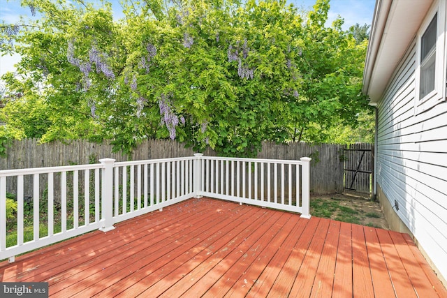 wooden deck with a fenced backyard