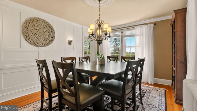477 Linton Hill Rd, Newtown, PA 18940 - dining area featuring baseboards, light wood finished floors, an inviting chandelier, ornamental molding, and a decorative wall