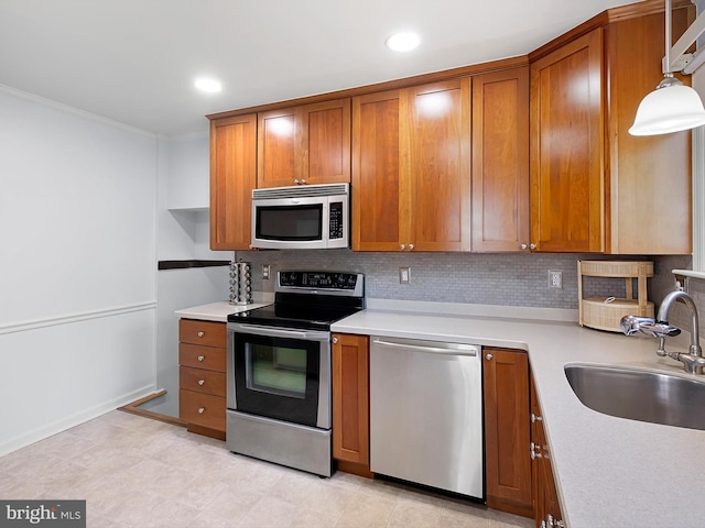 kitchen featuring decorative backsplash, a sink, brown cabinets, and stainless steel appliances