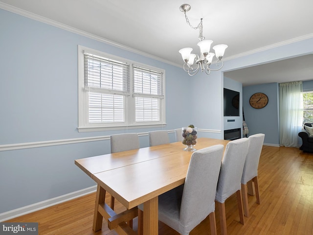 dining area with light wood-style floors, baseboards, and a chandelier