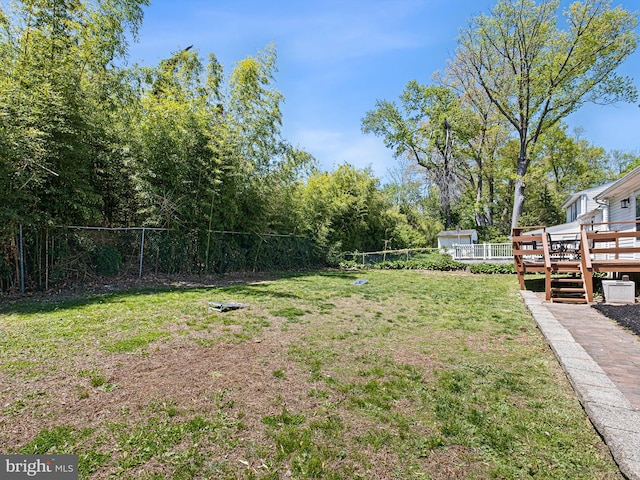 view of yard featuring fence and a wooden deck