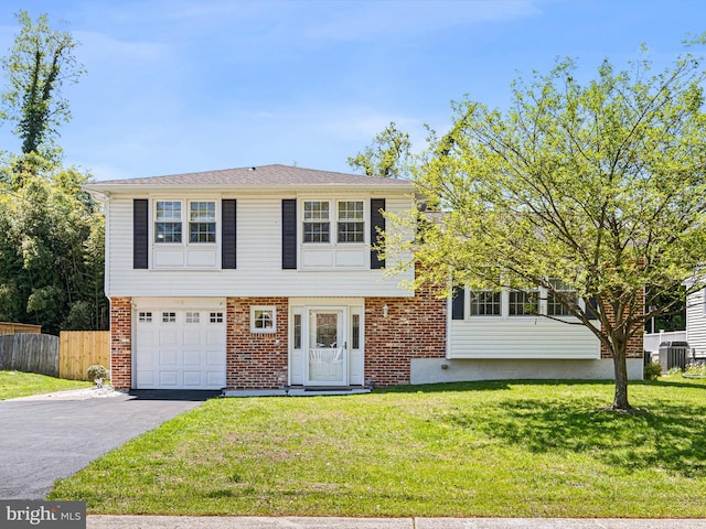 view of front of house featuring a garage, fence, brick siding, central AC unit, and driveway