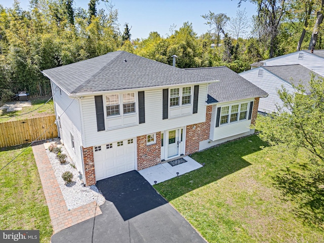 view of front of house featuring fence, roof with shingles, a front lawn, aphalt driveway, and a garage