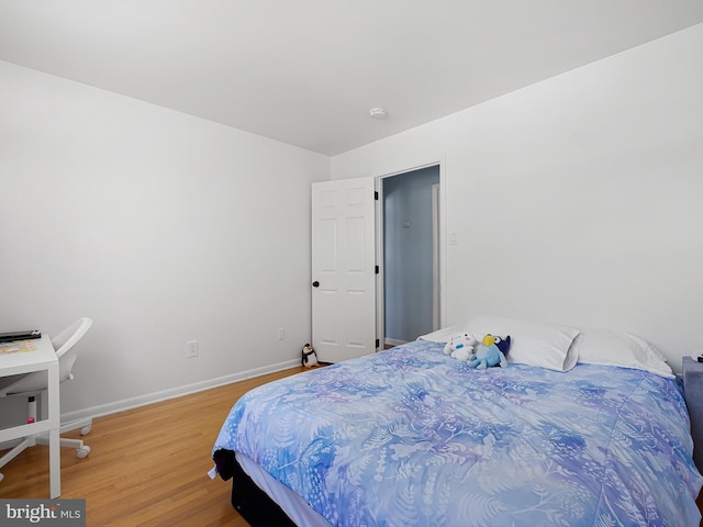 bedroom featuring baseboards and light wood finished floors