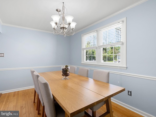 dining room featuring baseboards, an inviting chandelier, ornamental molding, and light wood finished floors