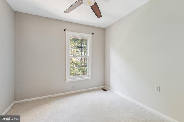 carpeted spare room with a ceiling fan, baseboards, and visible vents