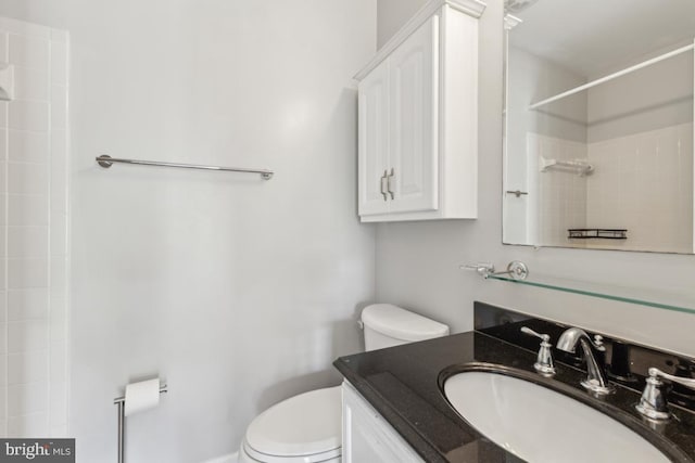 bathroom with vanity, walk in shower, and toilet