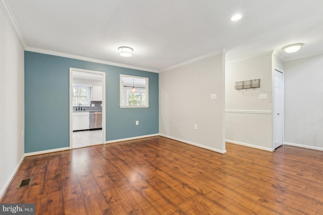 unfurnished room featuring baseboards, ornamental molding, and wood finished floors