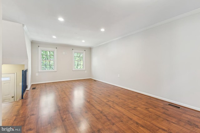 unfurnished living room featuring visible vents, ornamental molding, wood finished floors, baseboards, and recessed lighting