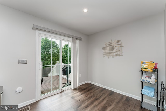 spare room with baseboards, dark wood-type flooring, and recessed lighting