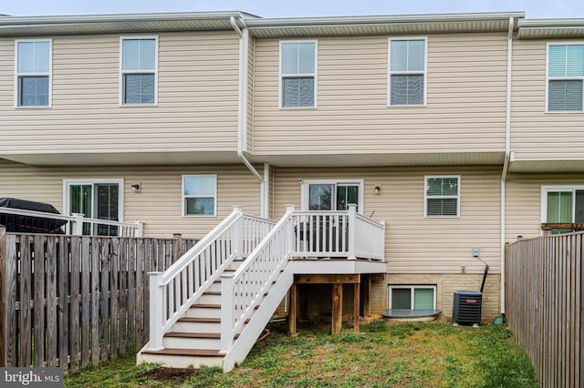 rear view of house featuring a fenced backyard, stairway, cooling unit, and a deck