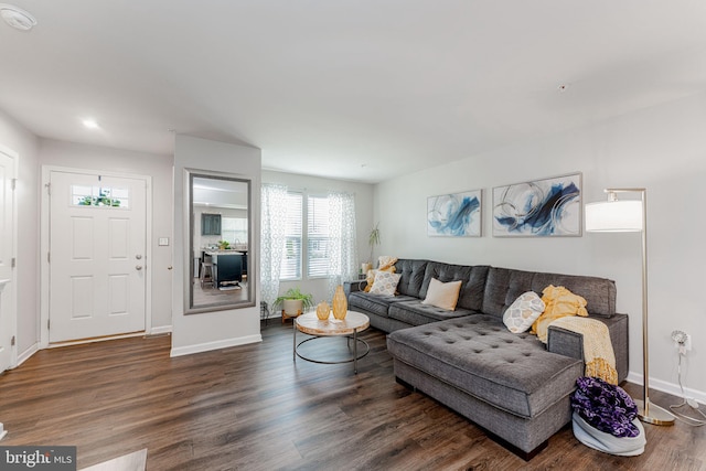 living area with baseboards and wood finished floors