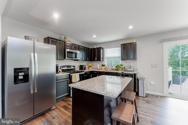 kitchen with appliances with stainless steel finishes, dark wood-type flooring, healthy amount of natural light, a sink, and recessed lighting