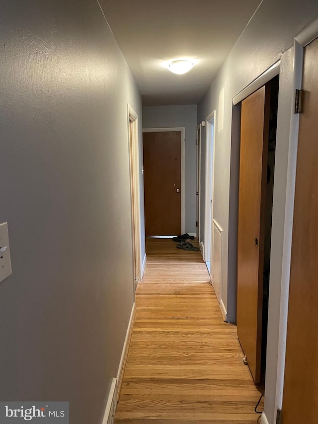 hallway with baseboards and light wood-style flooring