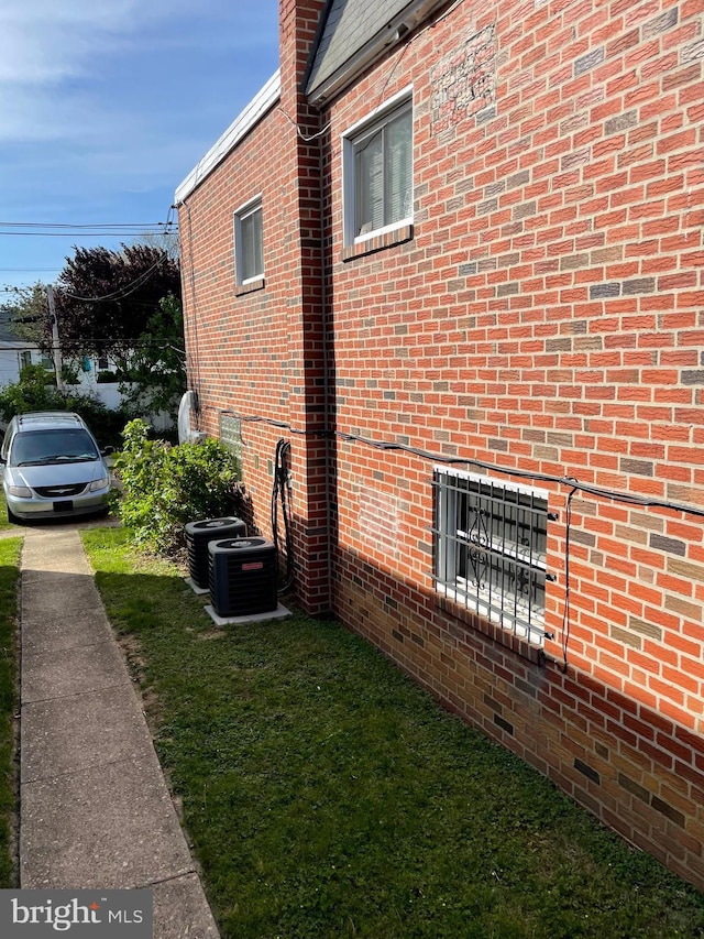 view of side of property with central AC and brick siding
