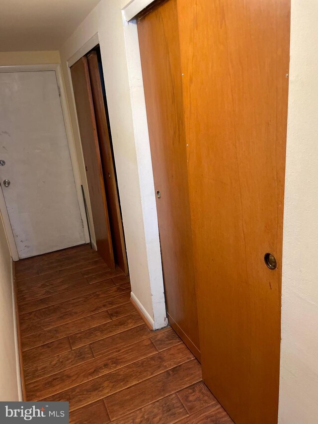 hall with dark wood-style flooring
