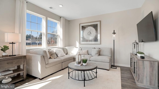 living room featuring light wood-style floors, baseboards, recessed lighting, and visible vents