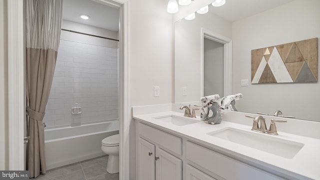 full bathroom featuring a sink, tile patterned floors, toilet, and double vanity