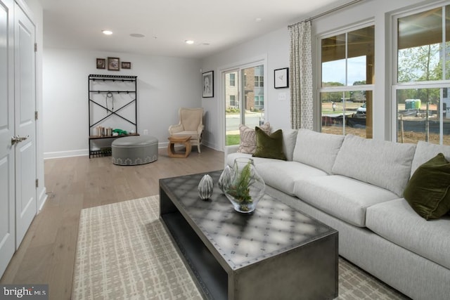 living room featuring recessed lighting, baseboards, plenty of natural light, and wood finished floors