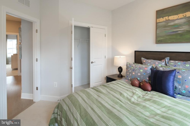 carpeted bedroom featuring baseboards, visible vents, and a closet