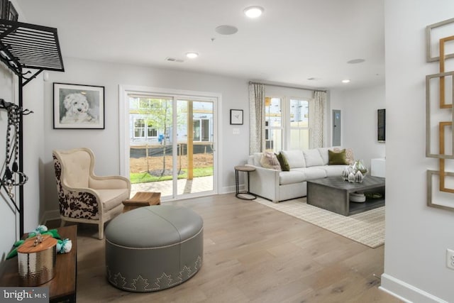 living area featuring recessed lighting, visible vents, a healthy amount of sunlight, and wood finished floors
